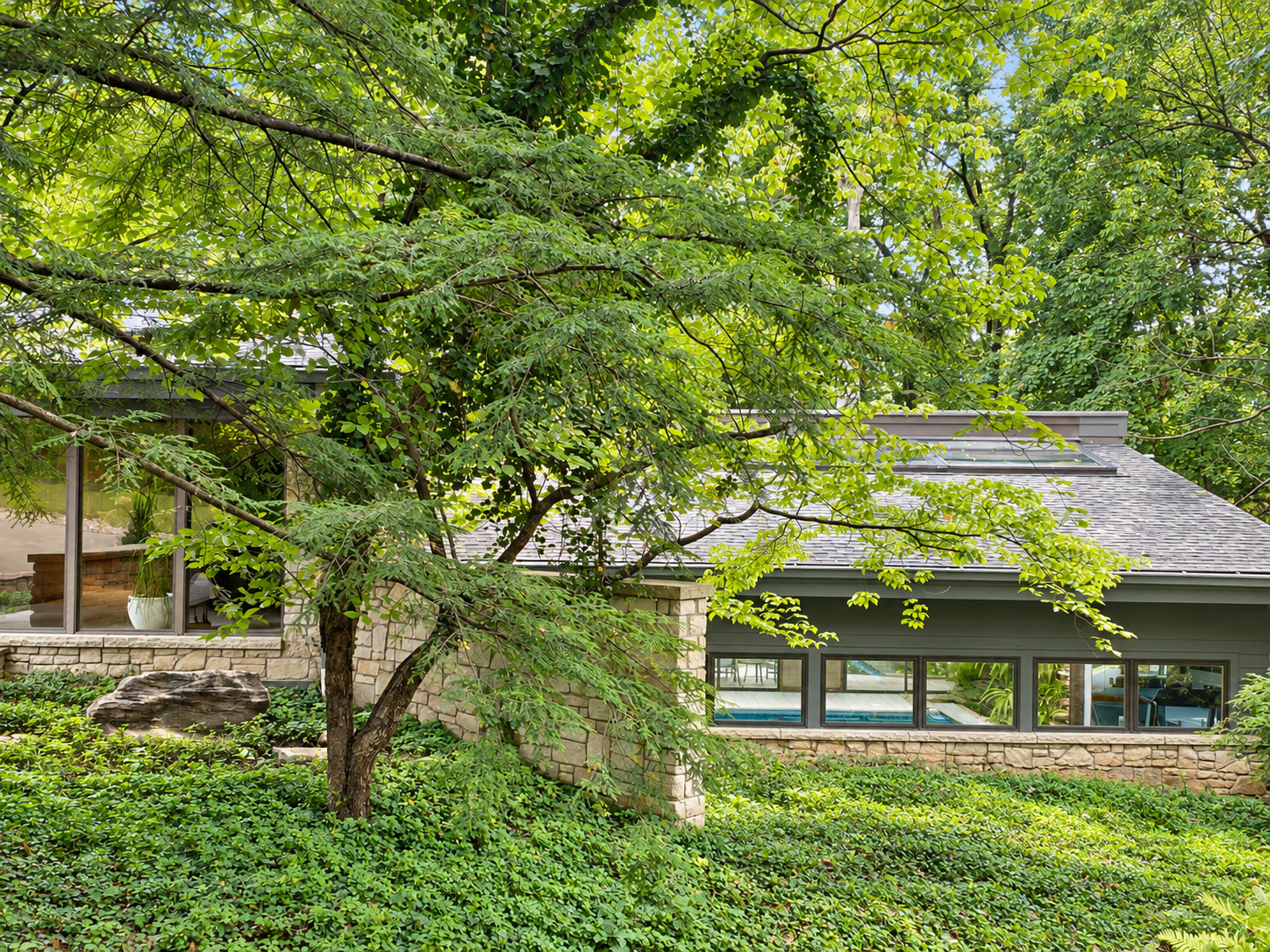 Before: tree-lined exterior of the home amid mature woodland landscaping